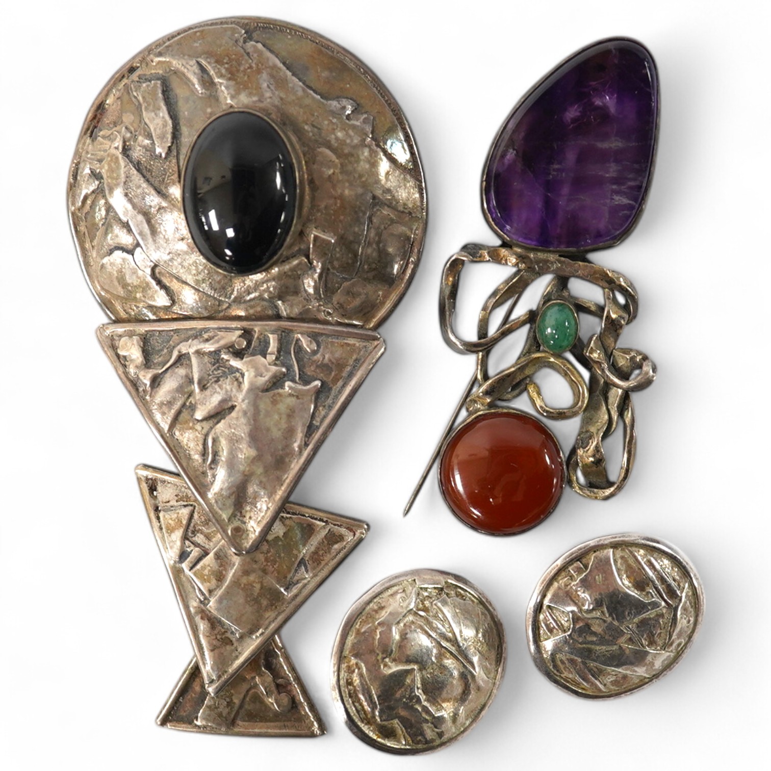 Elaine Coyne- A late 1980's modernist silver and cabochon garnet set drop brooch, 11.8cm, a pair of similar silver circular ear clips and a 1980's silver, carnelian, adventurine quartz and amethyst set brooch. Condition